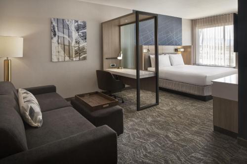 a hotel room with a couch and a bed and a desk at SpringHill Suites by Marriott Las Vegas Airport in Las Vegas