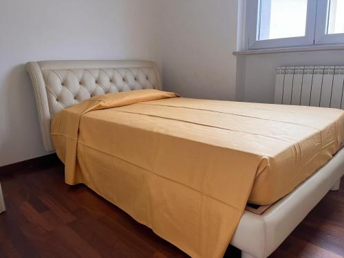 ペスカーラにあるAppartamento Pescara Sudのベッド(上に黄色の毛布付)