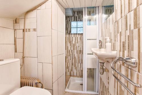a bathroom with a toilet and a sink at Villa Victor Hugo in Deauville
