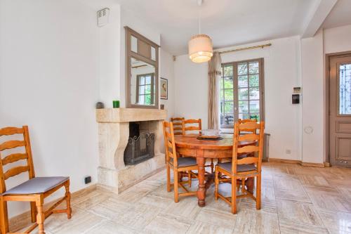 une salle à manger avec une table et des chaises et une cheminée dans l'établissement Villa Victor Hugo, à Deauville