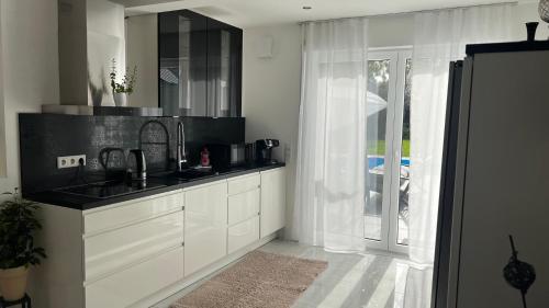 una cucina bianca con lavandino e finestra di LUXUS-RelaxDays-Apartments a Gütersloh