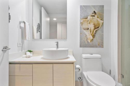 a white bathroom with a sink and a toilet at Convenient studio at Beach walk resort Miami 15th in Hollywood
