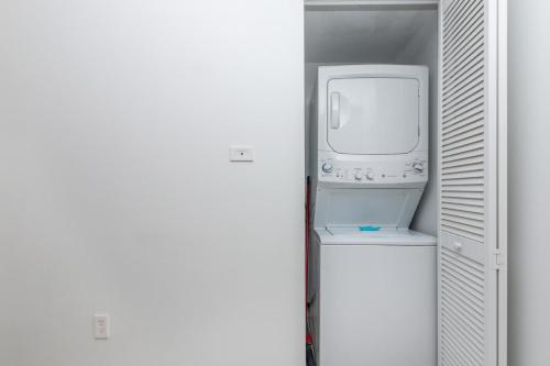 a bathroom with a washer and dryer next to a refrigerator at Modern one bedroom rental at Beach Walk resort Miami 18th floor in Hallandale Beach