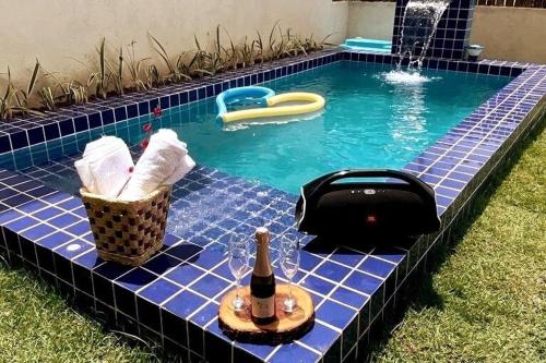 a swimming pool with a bottle of wine and a bottle of champagne at Casa Conchas do Patacho in Pôrto de Pedras