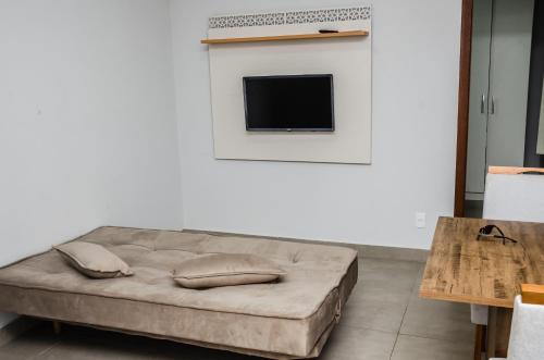 - un canapé avec des oreillers dans le salon dans l'établissement Apt 1 qto wifi - netflix - ar condicionado - prox ao metrô -ambiente familiar., à Ceilândia