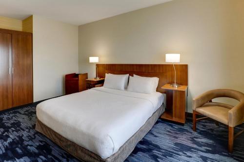 a hotel room with a large bed and a chair at Fairfield Inn and Suites Hutchinson in Hutchinson