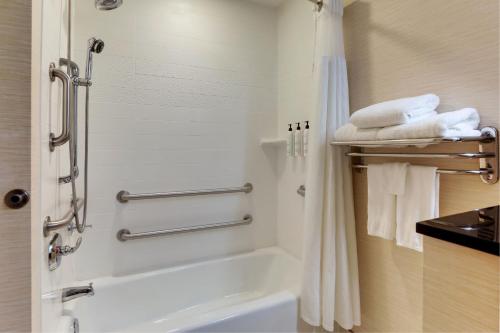 a bathroom with a tub and a shower with towels at Fairfield Inn and Suites Hutchinson in Hutchinson