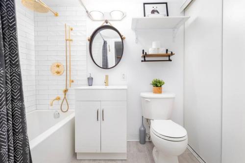 a bathroom with a toilet and a sink and a mirror at Charming 1BD Townhouse Near Lake in Toronto