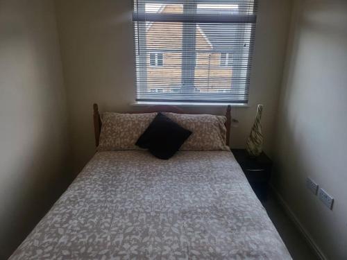 a bed in a small room with a window at The Haven Comfort in Harold Wood