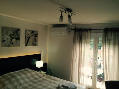 a bedroom with a bed and a window with a view at Park Srce Apartments in Arandelovac