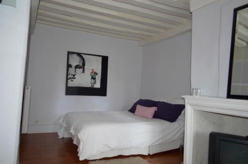 um quarto com uma cama branca e uma almofada rosa em Room in Guest room - Maison lAmerique welcome you to one of their rooms Dogs are also welcomed em Saint-Jean-le-Blanc
