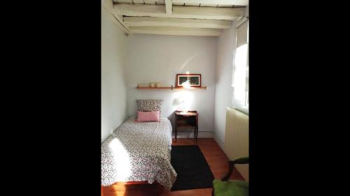 a small room with a bed and a table at Maison lAmrique welcome you to one of their rooms, Dogs are also welcomed in Saint-Jean-le-Blanc