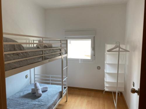 1 dormitorio con 2 literas y ventana en APARTAMENTO GOR, en Granada