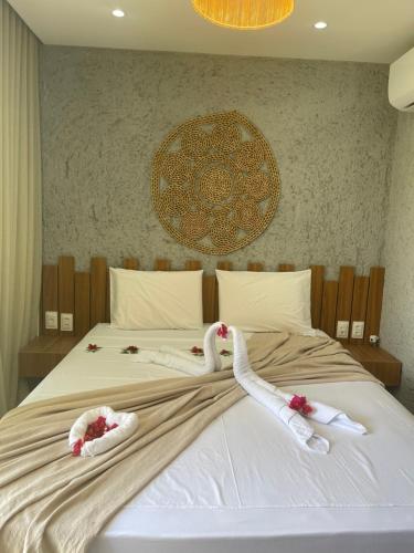 due cigni sono stesi su un letto con asciugamani di Nauru chalés milagres a São Miguel dos Milagres