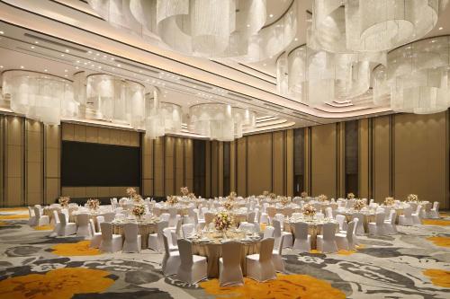 a large room with white tables and white chairs at Na Lotus Hotel, a Luxury Collection Hotel, Nanning in Nanning