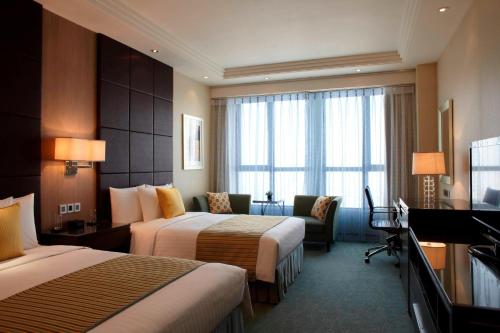 崑山市にあるCourtyard by Marriott Kunshanのベッド2台とテレビが備わるホテルルームです。