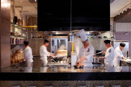 a group of chefs in a kitchen preparing food at Courtyard by Marriott Kunshan in Kunshan