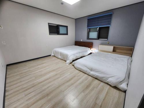 Habitación con 2 camas y suelo de madera. en Unseo Station 10mins - Max 6pax, BBQ, en Incheon