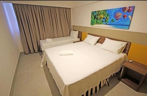 a hotel room with a bed and a window and a bed at Apartamento do lado do Thermas dos laranjais no Olímpia Park resort in Olímpia