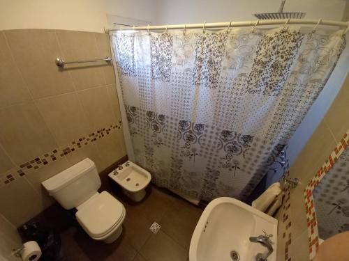 a bathroom with a toilet and a shower curtain at Altos de Adonai in Pueblo Quintana