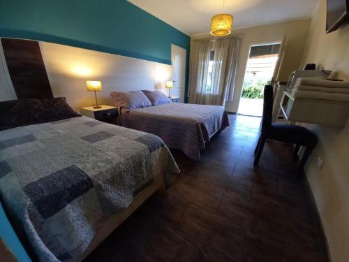 a hotel room with two beds and a chair at Altos de Adonai in Pueblo Quintana