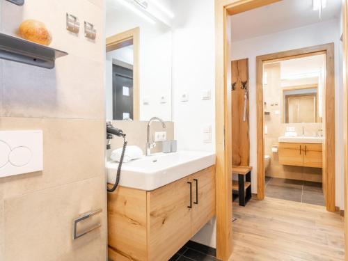 La salle de bains est pourvue d'un lavabo et d'un miroir. dans l'établissement Tauernlodge Carpe Diem, à Niedernsill
