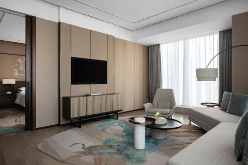 a living room with a couch and a tv at Hangzhou Marriott Hotel Lin'an in Lin'an