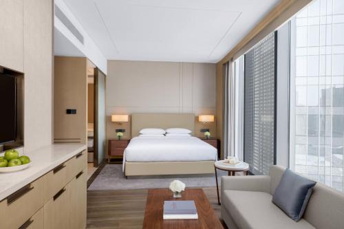 a bedroom with a bed and a living room at Courtyard By Marriott Xi'an North in Xi'an