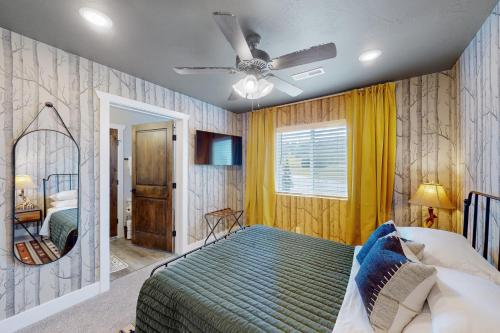 um quarto com uma cama e uma ventoinha de tecto em Crooked Cabin em Brian Head