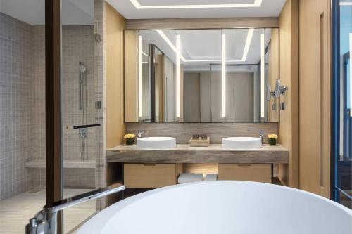 un bagno con due lavandini e un grande specchio di Courtyard by Marriott Jiangsu Taizhou a Taizhou