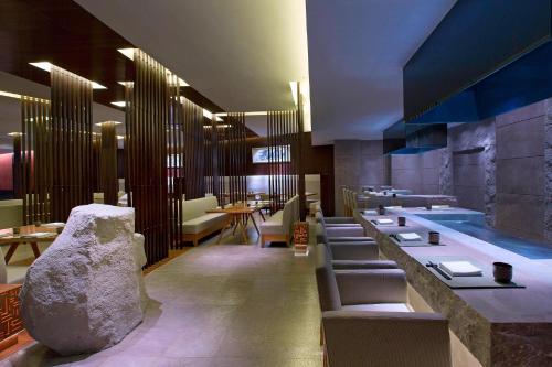 un restaurante con una fila de mesas y sillas en Sheraton Fuzhou Hotel, en Fuzhou