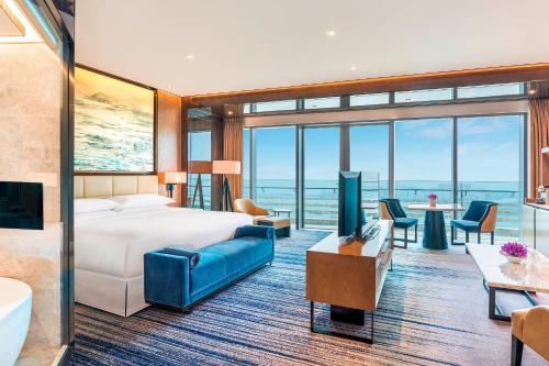a hotel room with a bed and a view of the ocean at Sheraton Zhuhai Hotel in Zhuhai