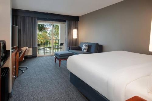 um quarto de hotel com uma cama e uma cadeira em Courtyard Fort Lauderdale SW Miramar em Miramar