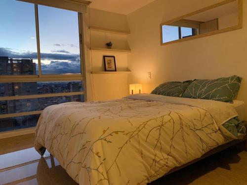 een slaapkamer met een bed en een groot raam bij Apt in Bogotá Downtown in Bogota