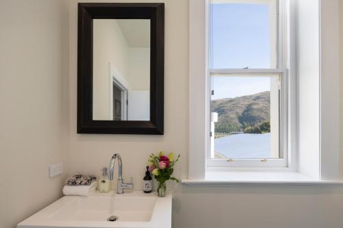 um lavatório de casa de banho com um espelho e uma janela em The Lord Clyde em Clyde