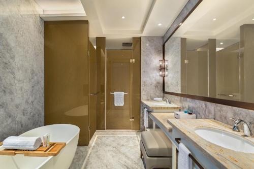 a bathroom with a tub and a sink and a shower at Le Meridien Suzhou, Suzhou Bay in Suzhou