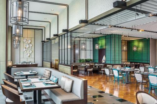a restaurant with tables and chairs in a room at Le Meridien Suzhou, Suzhou Bay in Suzhou