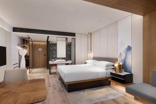 um quarto de hotel com uma cama e uma secretária em Fairfield by Marriott Taizhou Bay em Taizhou