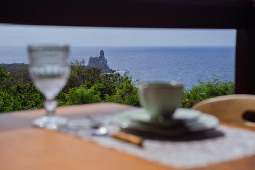 ein Glas Wein auf einem Tisch mit Meerblick in der Unterkunft Pousada Vila Nakau in Fernando de Noronha