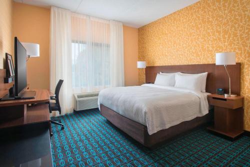 um quarto de hotel com uma cama e uma televisão em Fairfield Inn & Suites by Marriott Syracuse Carrier Circle em East Syracuse