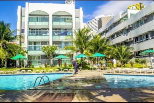 a resort with a swimming pool and a building at Ponta Negra Beach luxury hotel in Natal