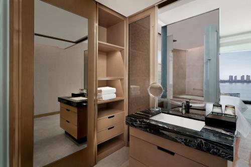 a bathroom with a sink and a mirror at Sheraton Qingdao West Coast in Huangdao