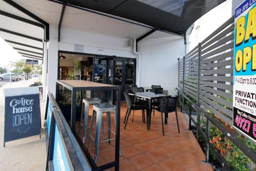 a restaurant with a table and chairs in a building at Coffee House Apartment Motel in Rockhampton