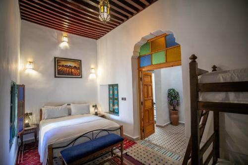 a bedroom with a bed and a ladder in a room at Riad Fes Allouch in Fez