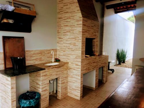 baño con lavabo y chimenea en Happy Guest House, en Navegantes