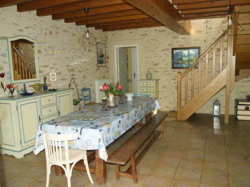 une salle à manger avec une table et une cuisine dans l'établissement Gîte rénové en campagne, 3 ch., terrain 5000m², proche randonnées et Le Mans ! - FR-1-410-161, à La Chabossière