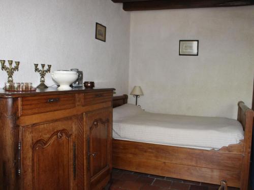 une chambre avec un lit et une commode en bois dans l'établissement Maison de campagne avec grand jardin, cheminée, vélos et wifi à Berfay - FR-1-410-242, à Berfay