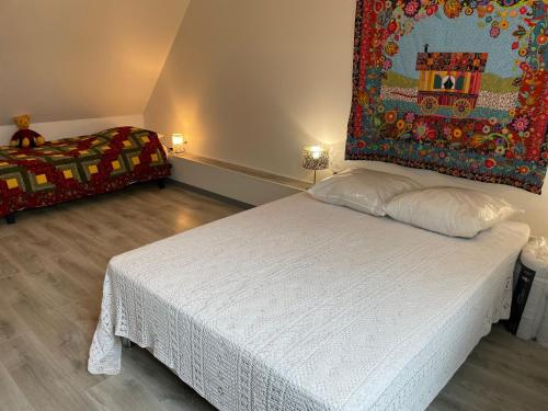 una camera da letto con un letto e un quadro sul muro di Gîte de charme près du Mans, tout équipé avec espace extérieur, garage, et confort moderne - FR-1-410-385 a La Bosse