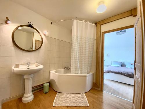 y baño con lavabo, bañera y espejo. en Gîte Autrepierre, 4 pièces, 6 personnes - FR-1-584-168 
