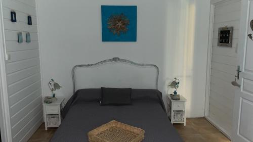 a small bedroom with a bed with two night stands at Casefilo in Sainte-Luce
